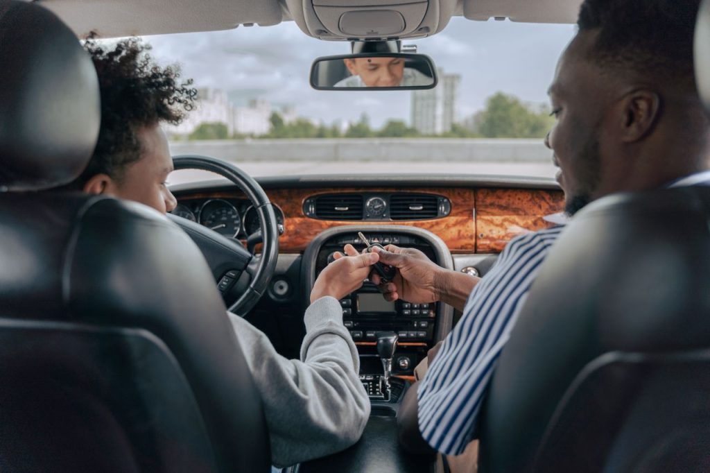 The Art of Drawing Readers In: Your attractive post title goes here Father and teenage son inside car learning to drive, fostering bonding and guidance.